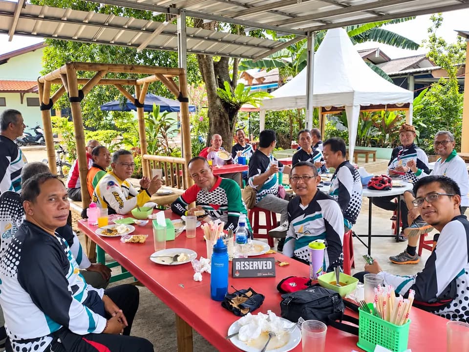 Pelanggan makan bersama di meja panjang di bawah tenda Mie Jeng-Kang